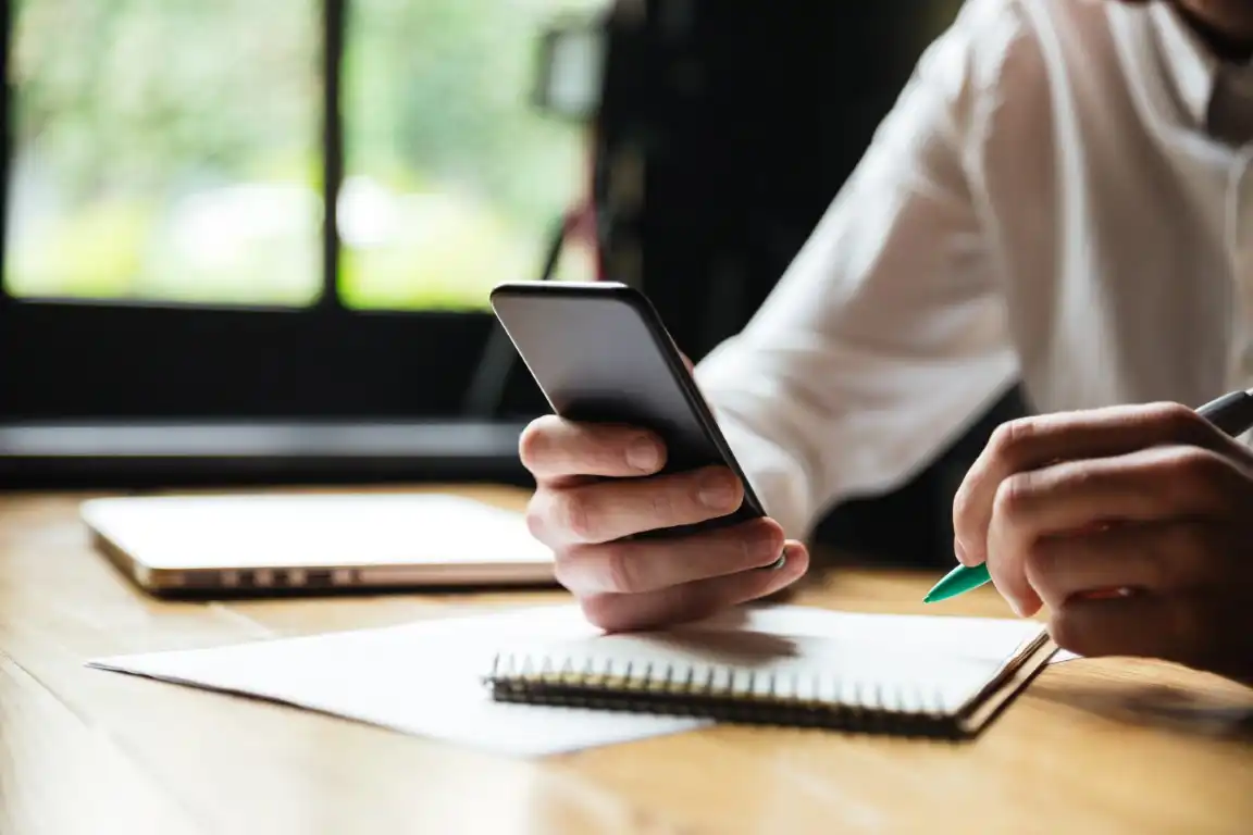 Main prenant un rdv avec son téléphone